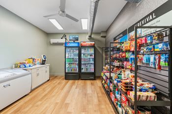 A room with a white wall and a black fridge.